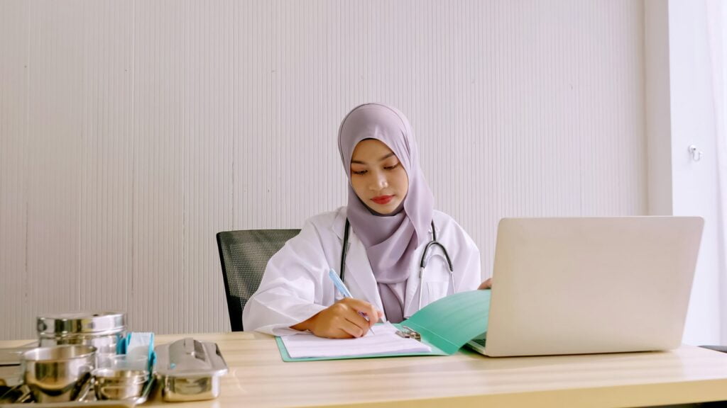 Muslim female doctor working at hospital room.